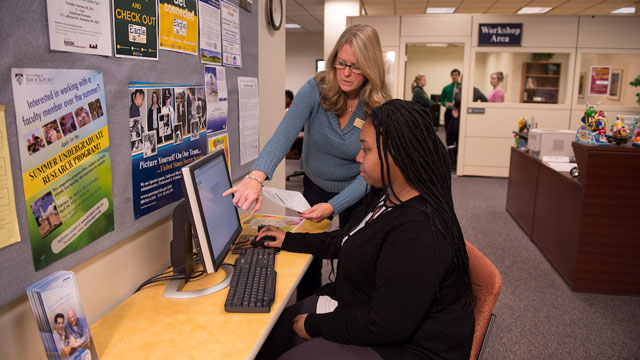 Picture of Financial Aid office, staff member assisting a student